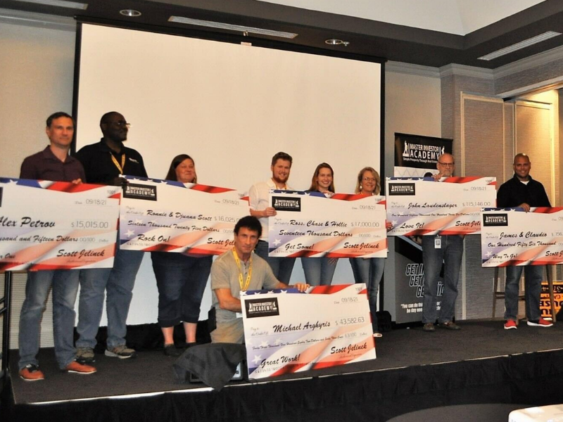 Attendees on stage with celebration checks